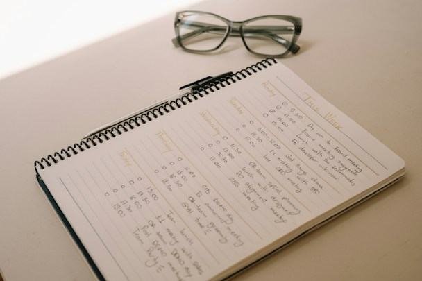 Handwritten course notes and glasses on a desk